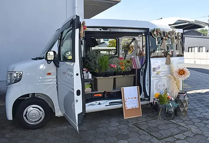 出店中の『花と風』の販売車。生花や鉢物が並んでいる様子